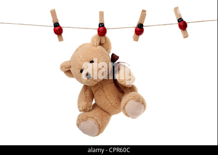 Petit ours en peluche accroché sur corde, isolé sur fond blanc Banque D'Images