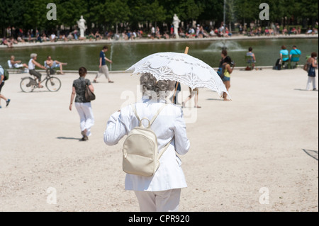 Paris, France - une femme âgée toutes élégamment vêtus de blanc tenant un parapluie Banque D'Images