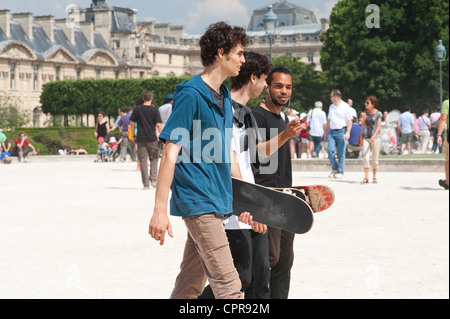 Paris, France - Trois jeunes hommes marchant dans les rues et tenant leurs skateboards Banque D'Images