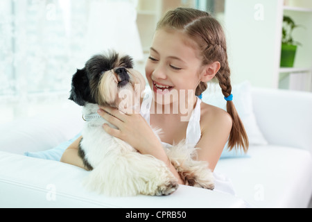 Portrait of happy girl holding shih-tzu chien et à le regarder Banque D'Images