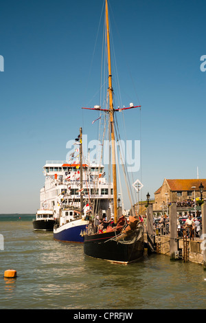 Fêtards et mélanger ensemble sur le quai pendant la vieilles coques à Yarmouth Festival sur l'île de Wight. Banque D'Images