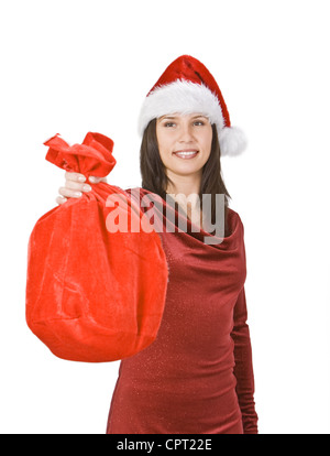 Jeune femme portant un chapeau de Père Noël rouge et offrant un sac plein de cadeaux. Banque D'Images