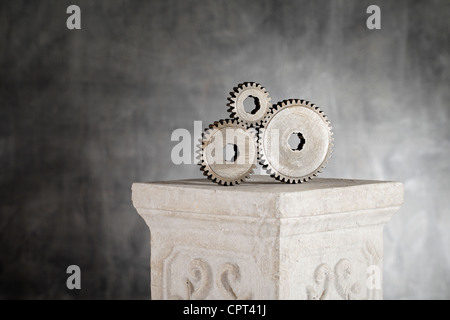 Vieux pignon crémaillère métallique des roues sur une colonne en plâtre. Banque D'Images