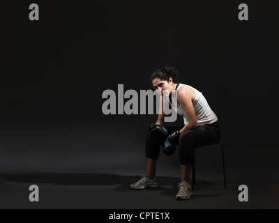 Portrait of female boxer assis sur fond noir Banque D'Images