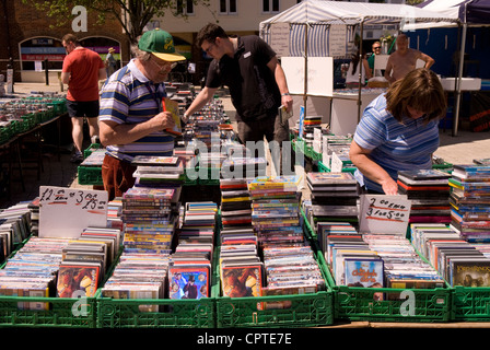 Les gens de lire un CD/DVD stand au marché de plein air hebdomadaire, Petersfield, Hampshire, Royaume-Uni. Banque D'Images