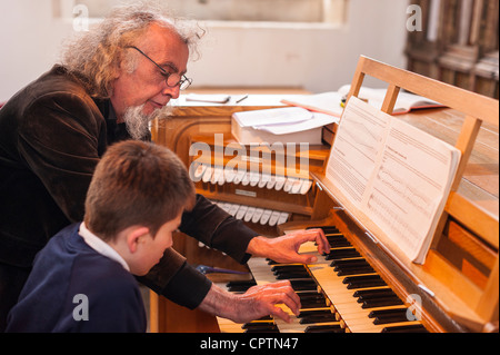 Un garçon de 12 ans de scolarité ayant sur la lecture d'un orgue d'église au Royaume-Uni Banque D'Images