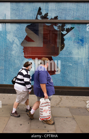 Les Londoniens passent par une grande silhouette de la reine Elizabeth la tête dans le magasin de vêtements de deviner dans Regent Street, au centre de Londres avant d'un week-end de célébrations nationales pour le monarque. Banque D'Images