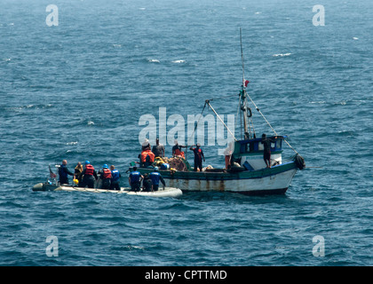 Les marins américains à bord d'un bateau gonflable à coque rigide, à gauche, aident un bateau de pêche péruvien handicapé dans l'océan Pacifique le 10 mai 2012, qui avait été bloqué pendant 10 jours après un échec de transmission. Les marins ont été affectés à la frégate de missiles guidés USS Underwood (FFG 36), qui a été déployée en Amérique centrale et du Sud et dans les Caraïbes à l'appui de la mer du Sud 2012. Southern Seas est une opération dirigée par le Commandement Sud des États-Unis conçue pour renforcer les relations avec les pays partenaires régionaux et améliorer la préparation opérationnelle de toutes les unités affectées. Banque D'Images