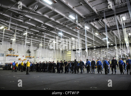 Des marins à bord du porte-avions japonais de classe Nimitz USS George Washington (CVN 73) participent à une promenade de débris de corps étrangers dans la baie hangar du navire. Les marins de George Washington patrouillent le pont de vol et les baies hangar pour s'assurer qu'aucun débris ne se trouve autour de vous et qu'il n'y a pas de dommages aux moteurs et hélices de l'avion. George Washington est à bord de Yokosuka, au Japon et prépare le retour en mer. Banque D'Images