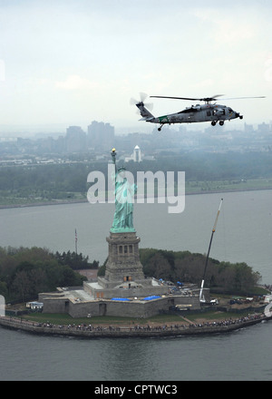 Un hélicoptère MH-60S Seahawk affecté à l'Escadron de combat en mer (HSC) 7 de Norfolk, en Virginie, passe devant la Statue de la liberté au début de la semaine de la flotte de New York 2012. Plus de 6,000 marins, marins et gardes-côtes sont arrivés à New York sur six navires de la Marine américaine, trois coupeuses de la Garde côtière américaine et 12 navires de la coalition. La semaine de la flotte commémorera le bicentenaire de la guerre de 1812 et la bannière étoilée. Banque D'Images