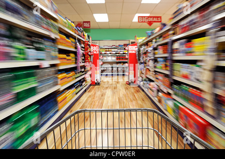 Shopping Trolley Speeding Down a Supermarket Aisle, UK. Banque D'Images