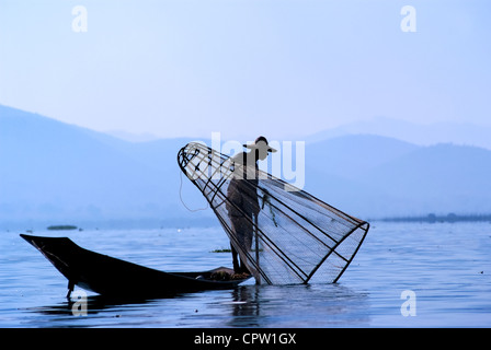 Pêcheur au Lac Inle gagne sa vie en utilisant une coop-comme piège à filet pour attraper des poissons Banque D'Images