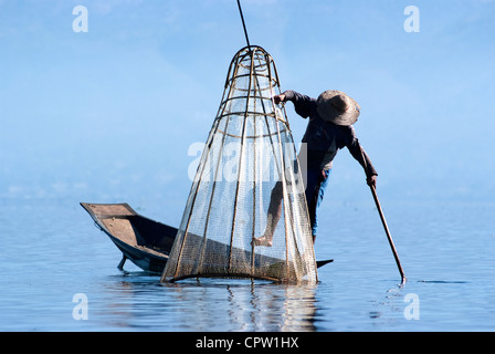 Pêcheur au Lac Inle gagne sa vie en utilisant une coop-comme piège à filet pour attraper des poissons Banque D'Images