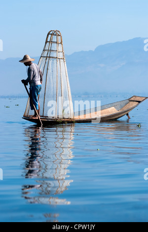 Pêcheur au Lac Inle gagne sa vie en utilisant une coop-comme piège à filet pour attraper des poissons Banque D'Images