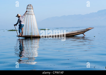 Pêcheur au Lac Inle gagne sa vie en utilisant une coop-comme piège à filet pour attraper des poissons Banque D'Images