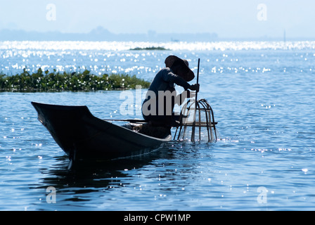 Pêcheur au Lac Inle gagne sa vie en utilisant une coop-comme piège à filet pour attraper des poissons Banque D'Images