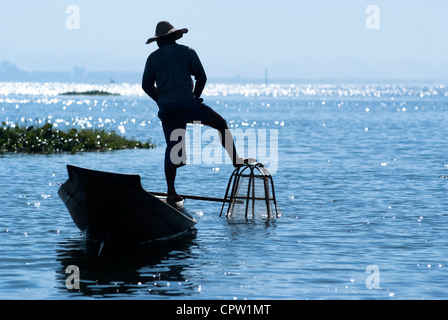 Pêcheur au Lac Inle gagne sa vie en utilisant une coop-comme piège à filet pour attraper des poissons Banque D'Images