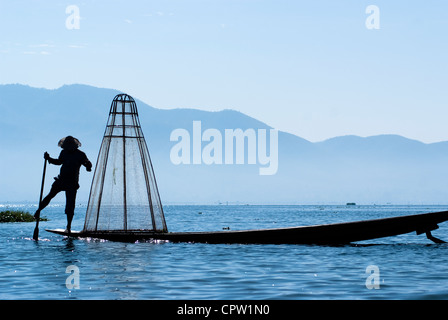 Pêcheur au Lac Inle gagne sa vie en utilisant une coop-comme piège à filet pour attraper des poissons Banque D'Images