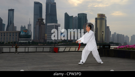 Panorama de l'épée de Tai Chi master en blanc et de kite flyer sur le Bund avec tours de Pudong à Shanghai le matin, République populaire de Chine Banque D'Images