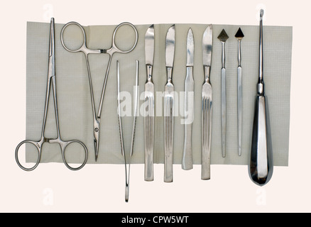 Les scalpels et un ensemble de différents instruments chirurgicaux sur une serviette et un fond blanc Banque D'Images