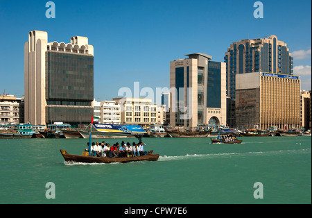 Abra watertaxis sur la Crique de Dubaï en passant par les banques et les bâtiments commerciaux sur la banque de Deira, Dubaï, Émirats Arabes Unis Banque D'Images