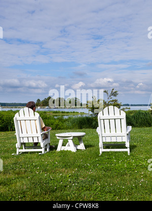 Chaises de patio à côté de la baie de Chesapeake qui donne sur le port de St Michaels avec senior male Banque D'Images