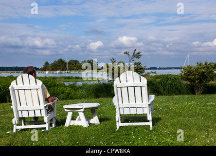 Chaises de patio à côté de la baie de Chesapeake qui donne sur le port de St Michaels avec senior male Banque D'Images