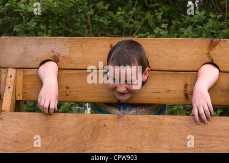 Jeune garçon avec la tête dans les stocks d'être fouettés avec des éponges humides à Dockenfield & fête la journée de célébration du Jubilé de diamant Banque D'Images