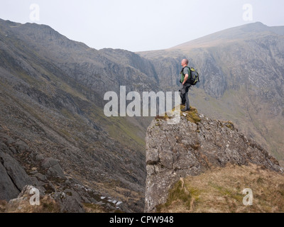 Une colline walker admire la vue de Cwm Idwal auprès de personnes âgées à l'approche de la crête, dans le Glyder Fawr Glyderau montagnes de Snowdonia Banque D'Images