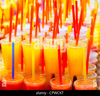 Jus de fruits frais naturels colorés verres avec paille empilés en rangées Banque D'Images