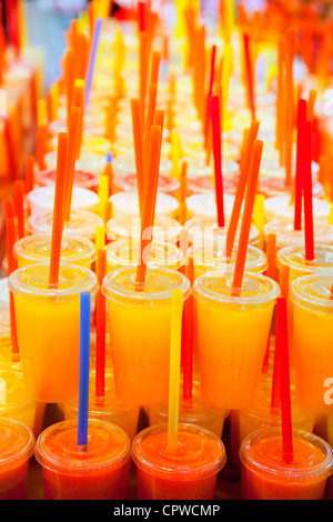 Jus de fruits frais naturels colorés verres avec paille empilés en rangées Banque D'Images
