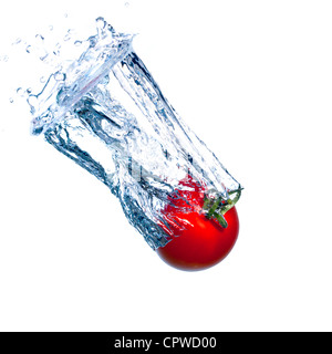 Tomate rouge tombe sous l'eau avec une éclaboussure, isolé Banque D'Images