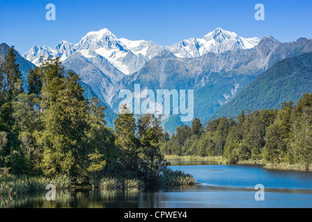 Lake Matheson avec la neige a couvert le mont Tasman et le Mont Cook, le plus haut sommet de Nouvelle-Zélande. Le Mont Cook est sur la droite. Banque D'Images