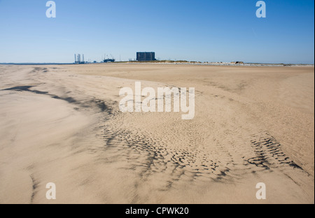 Du charbon sur les sables de la mer du Nord à la Gare, dans l'arrière-plan est la centrale nucléaire de Hartlepool Banque D'Images