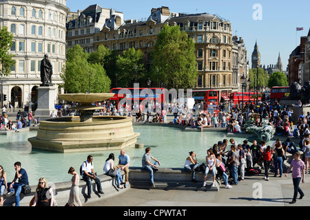 Les foules et les bus rouges à Trafalgar Square, Londres avec Big Ben en arrière-plan Banque D'Images