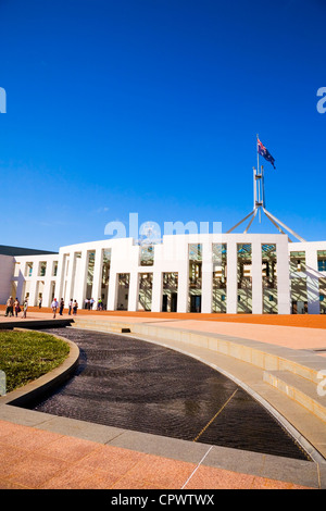 La Maison du Parlement, à Canberra, en Australie, avec le drapeau australien et un groupe de touristes à l'extérieur de profiter de l'ambiance. Banque D'Images