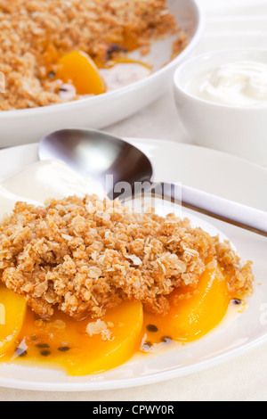 Crumble de fruits avec un peu de pêche et de fruit de la passion. Le crumble contient farine complète, le sucre brun et l'avoine. Banque D'Images