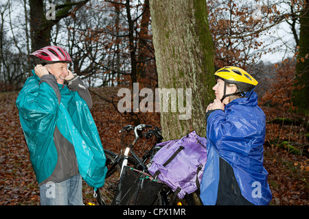 Senior couple prépare à cycle en forêt Banque D'Images
