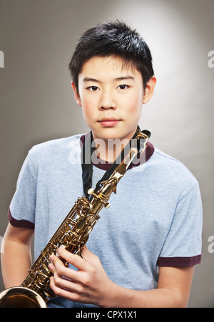 Portrait of young Asian Woman holding saxophone Banque D'Images