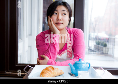 Femme propriétaire de penser pendant le petit-déjeuner Café Banque D'Images