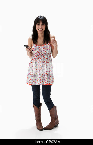 Smiling mature woman holding cellulaire, studio shot Banque D'Images