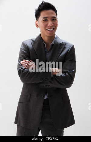 Young Asian businessman smiling, studio shot Banque D'Images