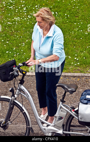 Femelle adulte cycliste sur son vélo parking vacances - France. Banque D'Images