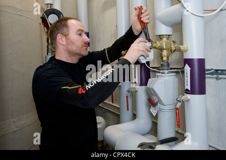 Technicien en chauffage et sanitaire installer une soupape de moteur Banque D'Images