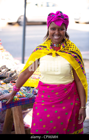 Vendeur de rue habillés en vêtements traditionnels sourit à l'appareil photo Banque D'Images