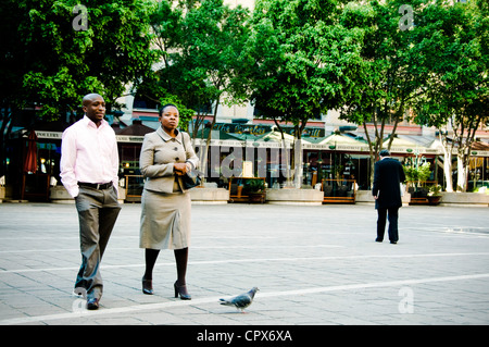 Deux personnes marchant dans la place Nelson Mandela, Sandton, Afrique du Sud Banque D'Images