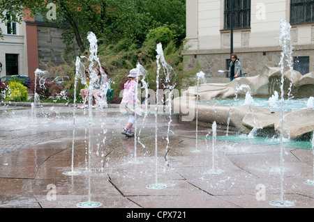 Enfant jouant près de la fontaine, Cracovie, Pologne. Banque D'Images