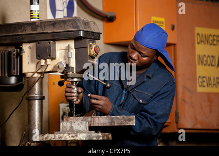 Travailleur d'usine dans la perceuse à colonne d'exploitation d'usine de l'aimant, Gauteng, Afrique du Sud Banque D'Images