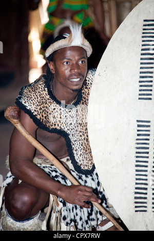 Un danseur traditionnel de l'Afrique de l'homme à genoux sur le sol Banque D'Images