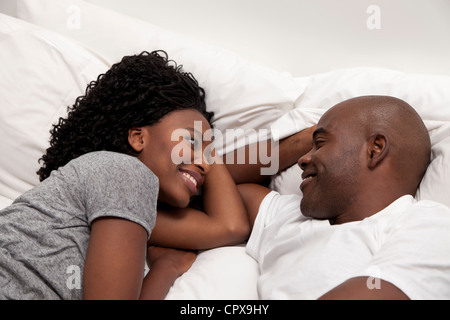 Jeune black couple allongé sur un lit ensemble Banque D'Images